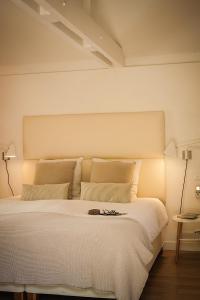 een slaapkamer met een groot wit bed met verlichting bij Chambre d'hôtes Clos du Petit Jésus in Cassis