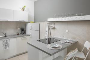 uma cozinha com um frigorífico branco e uma mesa com dois pratos em Studio apartment close to the sea em Rabac