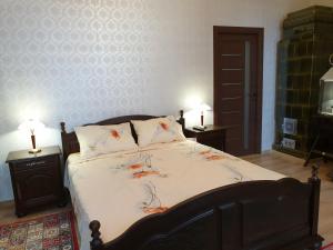 a bedroom with a large bed with two lamps on tables at Casa Kogalniceanu in Constanţa