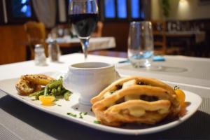 a plate of food on a table with a glass of wine at Source de la Vallée in Sadroc