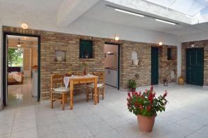 a patio with a table and chairs and a brick wall at Damaskis Kassiopi Studios in Kassiopi