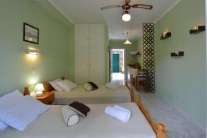 a bedroom with two beds and a hallway at Damaskis Studios in Kassiopi