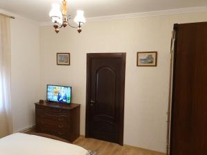 a bedroom with a bed and a door and a television at Casa Kogalniceanu in Constanţa