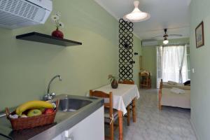 cocina y sala de estar con fregadero y mesa en Damaskis Studios, en Kassiopi