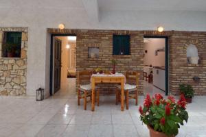 a dining room with a table and chairs and a brick wall at Damaskis Kassiopi Studios in Kassiopi +29 photos