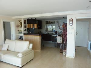 a living room with a white couch and a kitchen at Jacqueline in Salou