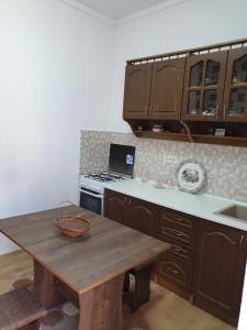 a kitchen with wooden cabinets and a wooden table at Casa Kogalniceanu in Constanţa