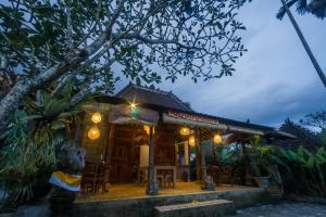 a restaurant with a building with lights on it at Green Taman Ubud by Prasi in Ubud