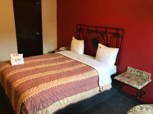 een slaapkamer met een groot bed en een stoel bij Motel El Refugio in Tijuana