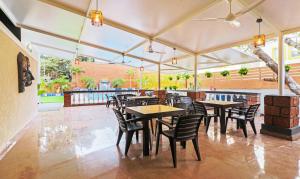 a restaurant with tables and chairs in a building at Treebo Trend Dona Eliza 700 metres from Calangute Beach in Calangute