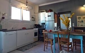 a kitchen with a table and a refrigerator at Les Sauges in Isigny-sur-Mer