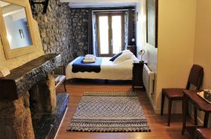 a bedroom with a bed in a room with a fireplace at L'Auberge De Montpezat in Montpezat-sous-Bauzon