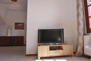 TV de pantalla plana en la parte superior de un centro de entretenimiento de madera en Villa Elizabeth Athos, en Ouranoupoli