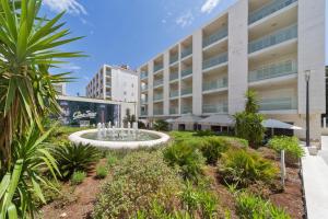 a large building with a fountain in front of it at Dubrovnik Luxury Apartment Lapad in Dubrovnik