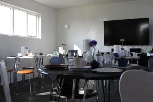 a dining room with a table with chairs and a flat screen tv at Holssel road 864 in Myvatn