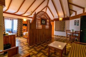 Pokój z sypialnią z łóżkiem i stołem w obiekcie The Tall Trees w mieście Munnar