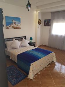 - une chambre avec un grand lit et une couverture bleue dans l'établissement TANJITAN HOSPITALITE, à Tanger