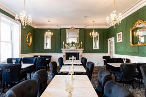 a restaurant with green walls and tables and chairs at Lansdowne House with Private Car Park in Llandudno +97 photos
