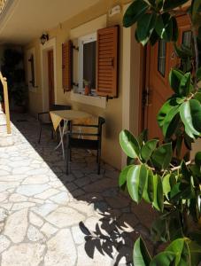 a patio with a table and chairs and a window at Epi Apartments in Lourdata