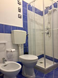 een badkamer met een toilet en een glazen douche bij Trio D'Archi - La Maison de Cocò in Caltagirone