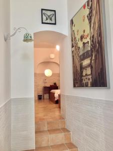 a hallway with a tile floor and a clock on the wall at Trio D'Archi - La Maison de Cocò in Caltagirone