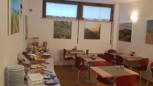 una sala da pranzo con tavoli e sedie con cibo sopra di Villa Tuscany Siena a Siena