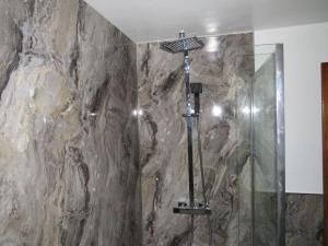 Un baño con ducha con pared de piedra. en Criffel Cottage, en Dumfries 15 fotos más