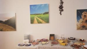 a table with plates of food on it with paintings at Villa Tuscany Siena in Siena