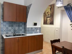 una cucina con lavandino e una sala da pranzo di Trio D'Archi - La Maison de Cocò a Caltagirone
