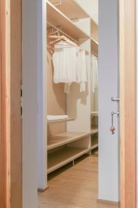 a walk in closet with white clothes on racks at Wonderful Brera flat in Milan