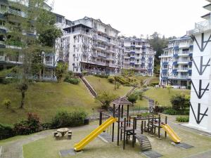 a playground with a yellow slide in front of buildings at Desa Anthurium in Cameron Highlands