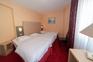 Postel nebo postele na pokoji v ubytování Hotel Majestic Alsace - Strasbourg Nord