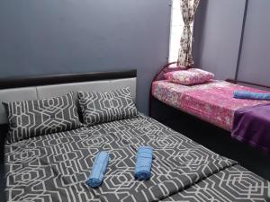 a bedroom with a bed and pillows on a bed sidx sidx sidx at Anis Homestay Gua Musang in Gua Musang +4 photos