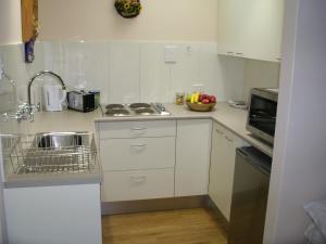 a small kitchen with white cabinets and a sink at Adelaide Hills B&B Accommodation in Stirling