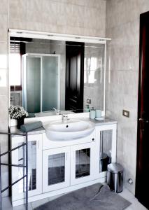 La salle de bains est pourvue d'un lavabo blanc et d'un miroir. dans l'établissement Casa Lory, à Mestre