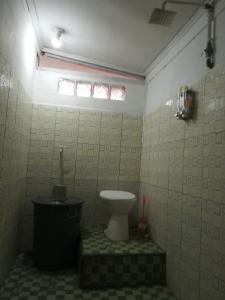 a bathroom with a toilet and a window in it at Pondok Oma in Lasikin