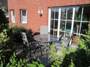 a patio with a table and chairs in front of a brick building at Ferienwohnung Erlenhof in Engelskirchen