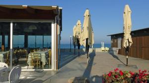 un restaurant avec des tables et des parasols et l'océan dans l'établissement La Magnolia, à Porto SantʼElpidio