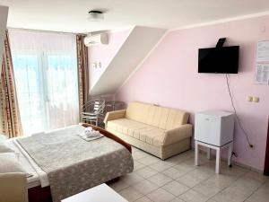 a bedroom with a bed and a couch and a tv at Pansion Begic in Omiš