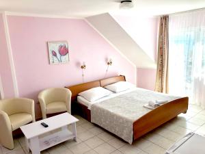 a bedroom with a bed and two chairs at Pansion Begic in Omiš