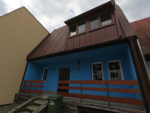una casa azul con techo marrón y banco en Frymburk 210, en Frymburk