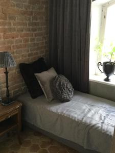 un letto in una camera con un muro di mattoni e una finestra di The Piano Shop a Gränna