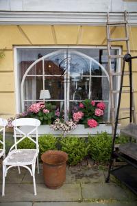 una finestra con un mazzo di fiori e una sedia di The Piano Shop a Gränna