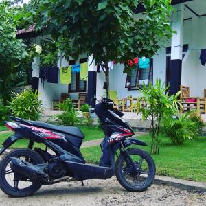uma moto estacionada ao lado de uma rua em Nanda Homestay em Kuta