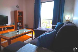 Una sala de estar con un sofá y una mesa de café. en Apartamento Estefânia, en Santa Cruz
