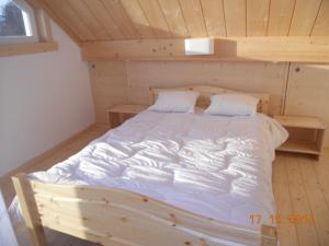 a bedroom with a bed in a wooden room at Bungalow du Lac in Froid-Chapelle