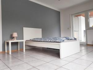 Cama en habitación con lámpara y mesa en Monteurzimmer Obersulm en Obersulm