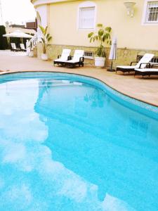 uma piscina com água azul num hotel em Vickys Villa em Puerto Marino