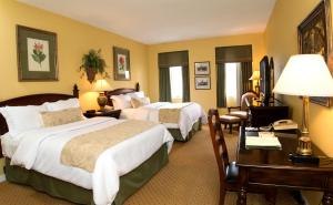 a hotel room with two beds and a desk at Nassau Inn in Princeton