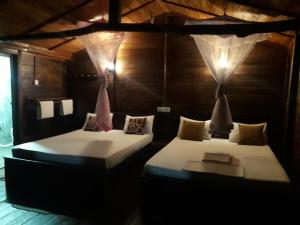 two beds sitting in a room with lights at Golden Rainbow Guest House in Dambulla